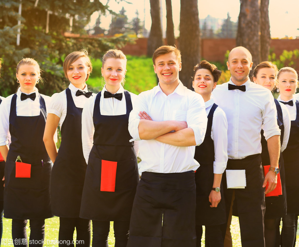 大群的服務員與女服務員站在行